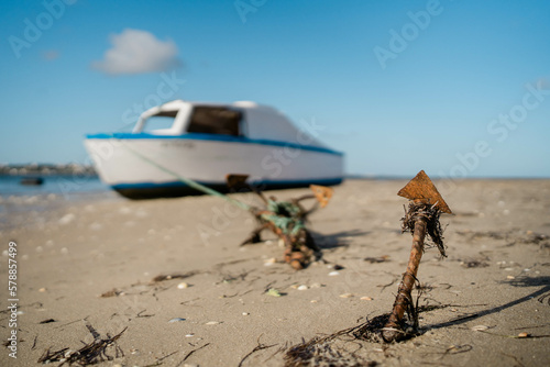 Barca all'ancora sulla spiaggia a causa della bassa marea Fototapet