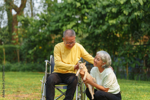 Elderly couple husband and wife happy asian people giving love and care Wheelchair in the park relaxing in spring, relaxing and walking outside at the park.