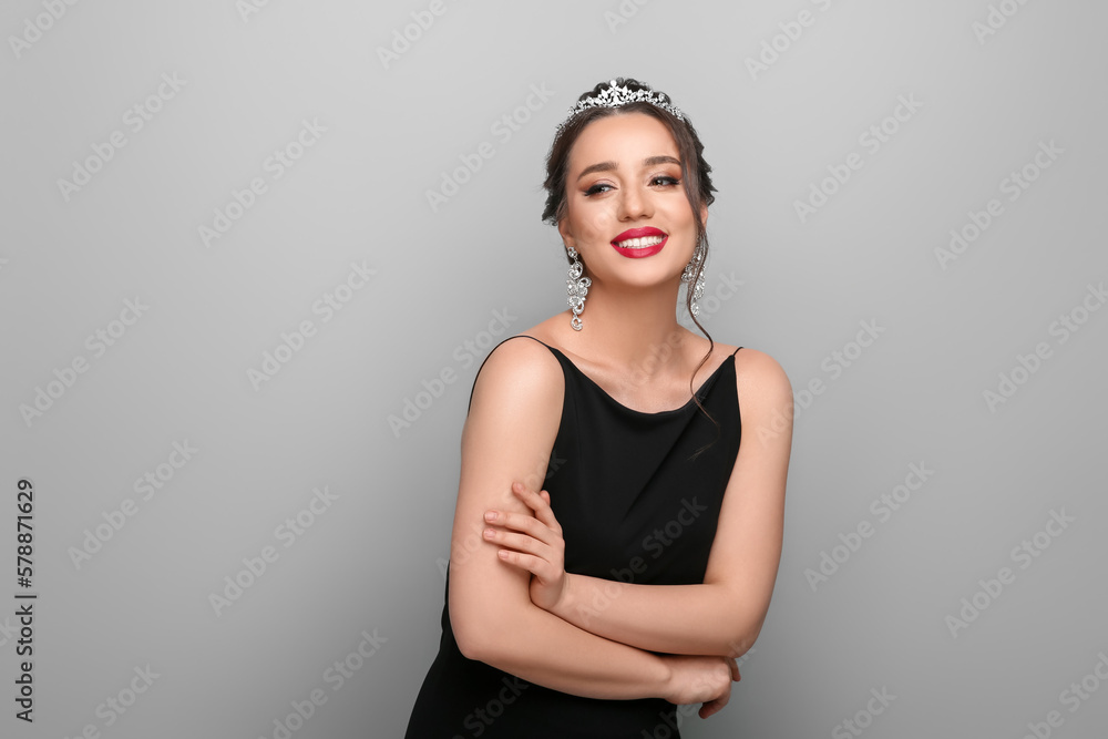 Fototapeta premium Beautiful young woman wearing luxurious tiara on light grey background, space for text
