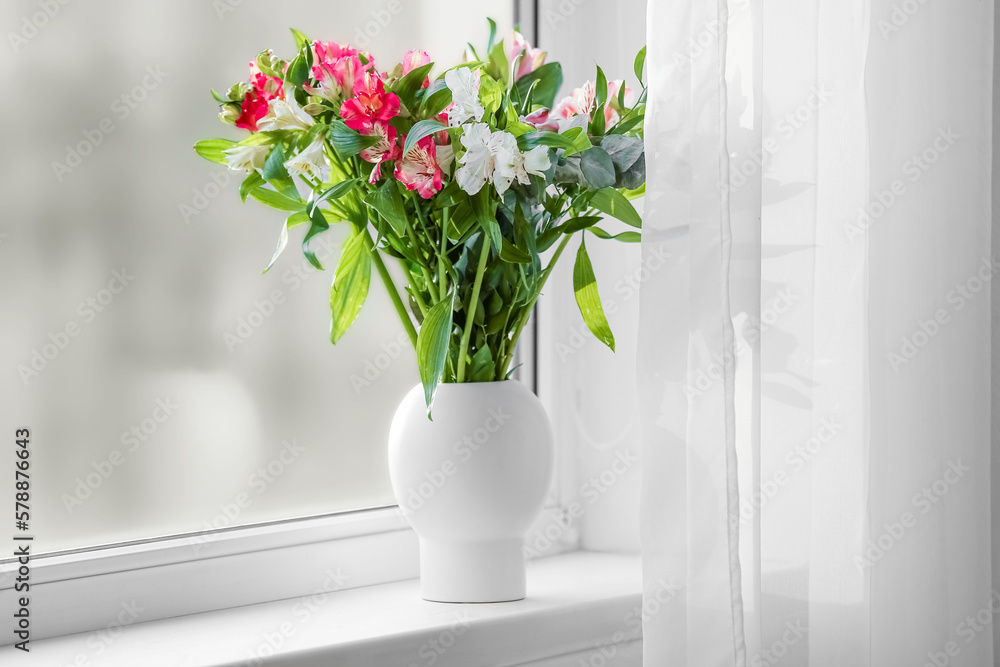 Vase with beautiful alstroemeria flowers on windowsill