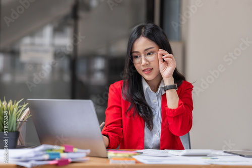 Asian businesswoman analyzing reports while working in workplace office.