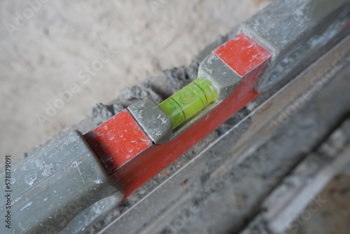selectively focus on spirit level, also called waterpass or water level. Level to Check Bricklaying Foundation Wall Outdoors. soft focus