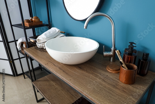 Sink with bath accessories on table in bathroom