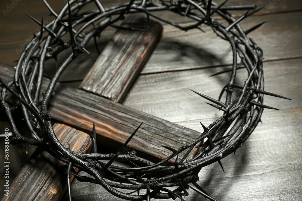 Crown of thorns with cross on dark wooden background, closeup