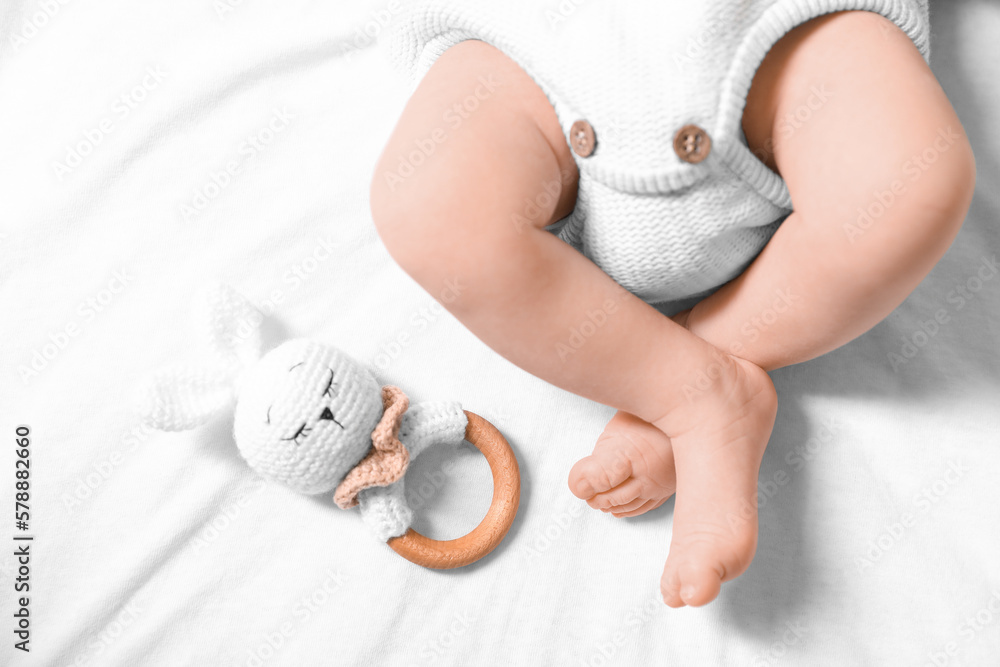 Newborn baby with toy bunny lying on bed, top view Newborn baby with toy bunny lying on bed, top view