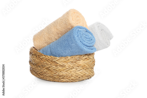 Wicker basket with rolled bath towels isolated on white