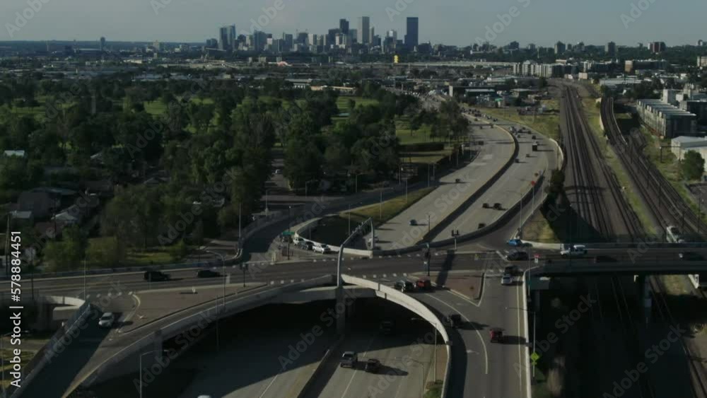 Drone following tilt shot of cars driving over the highway towards the skyline of Denver. Drone following tilt shot of cars driving over the highway towards the skyline of Denver.