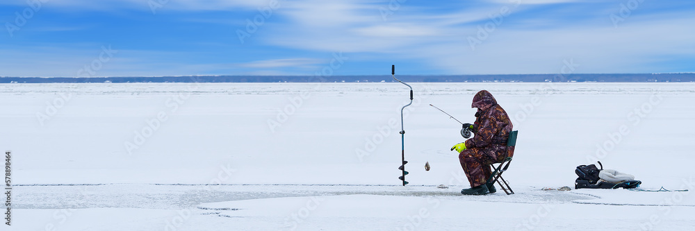 Ice fishing. lonely man fishing for perch. Winter fishing as hobby, Winter activity in Scandinavia. Hobby, winter free time concept