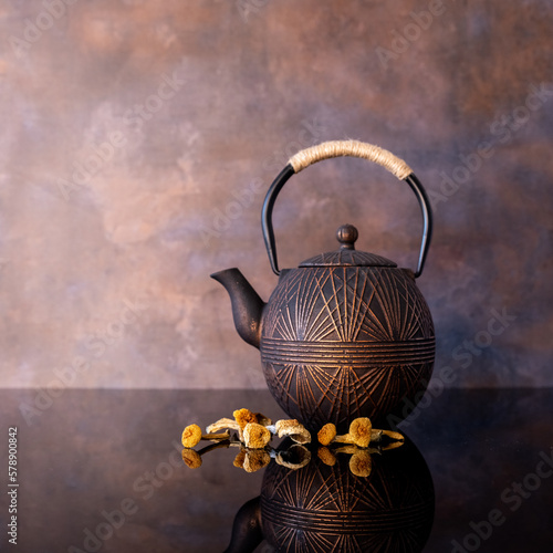 Brown metal tea kettle with dried mushrooms