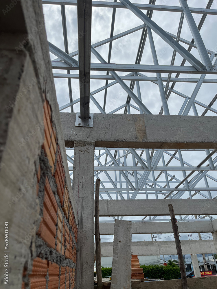 Obraz premium structure steel roof building construction. scene gabal roof structure with steel metal under construction building view and blue sky. structure for house, roof gable, construction home, real estate.