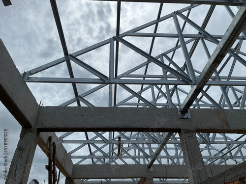 structure steel roof building construction. scene gabal roof structure with steel metal under construction building view and blue sky. structure for house, roof gable, construction home, real estate. photo
