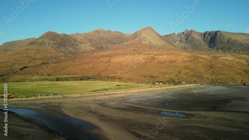 Flying over gravel beach towards Red Cuillin mountains at sunset at Glenbrittle Isle of Skye Scotland photo