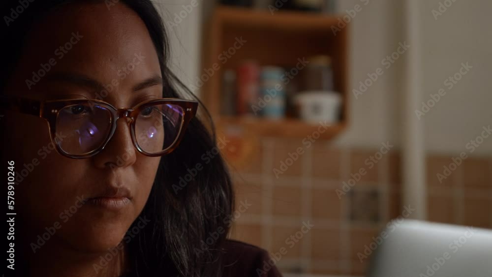 Woman concentrates on her work on her laptop in an apartment