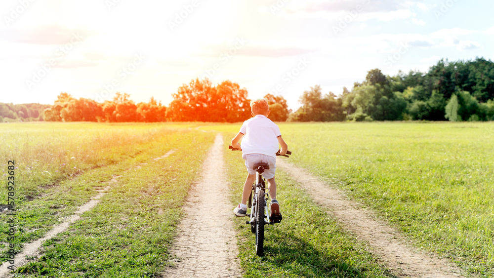 a boy rides a bicycle in nature