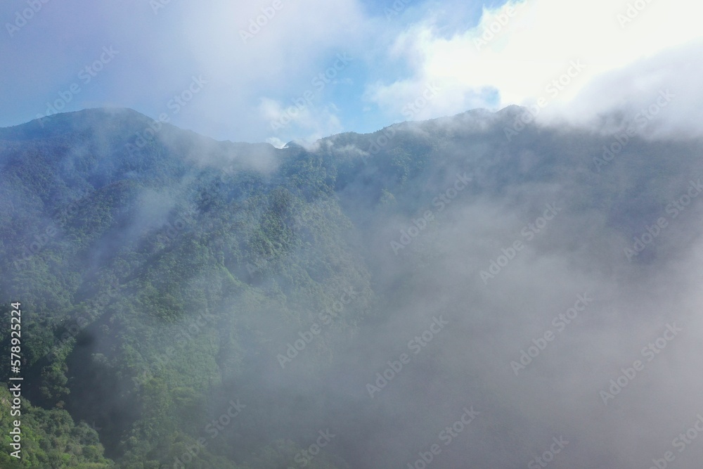 Panoramic view of a rainforest valley on Flores surrounded by a dense layer of haze clouds.