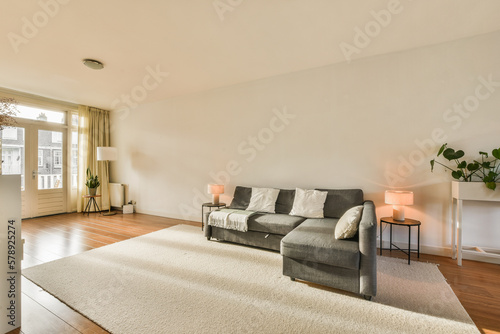 Принти на полотні a living room with white walls and hardwood flooring, including a grey couch in