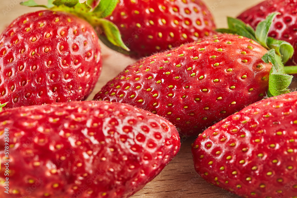 Fresh selected strawberries, stacked in slide on wooden background Fresh selected strawberries, stacked in slide on wooden background