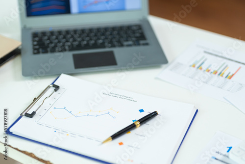 business desk with keyboard report chart pen and tablet on white table