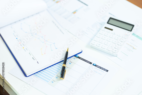 business desk with keyboard report chart pen and tablet on white table