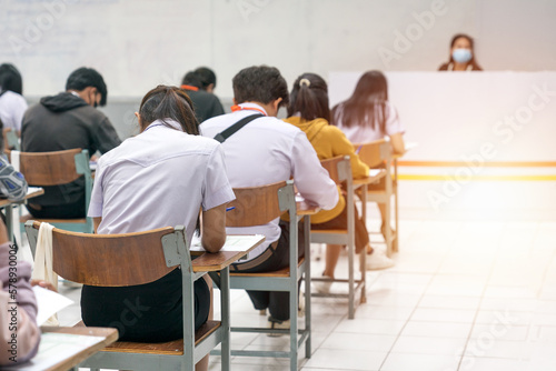 University students concentrating on doing examinations in the classroom