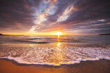 Beautiful sunrise over the sea waves and beach shore