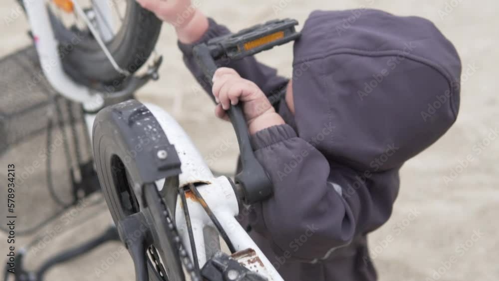 A young child learns an adult parent's bicycle A young child learns an adult parent's bicycle