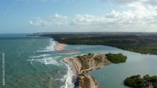 Descending aerial drone wide shot of the beautiful coastline of Gramame where the ocean meets the river near the tropical beach capital city of Joao Pessoa in Paraiba, Brazil on a warm summer day. photo