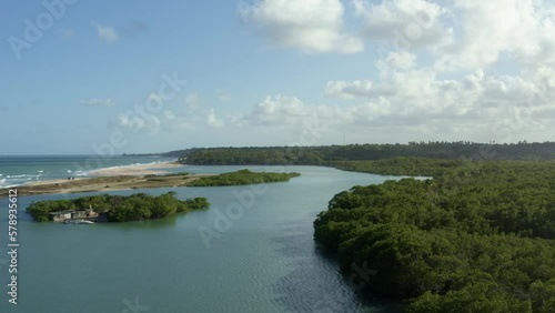 Dolly in aerial drone wide shot of the large winding tropical Gramame river where it meets the ocean near the tropical beach capital city of Joao Pessoa in Paraiba, Brazil on a warm summer day. photo