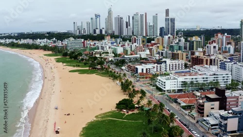 Tilting up dolly out aerial drone shot of the cityscape of the colorful tropical beach capital city of Joao Pessoa in Paraiba, Brazil from the Tambaú neighborhood on an overcast morning. photo