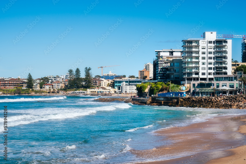 Coastal erosion at North Cronulla Beach in Sydney, NSW, Australia. A huge amount of sand was ripped from the beach and the ocean reached close up to the sea wall and nearby buildings in June 2022. - obrazy, fototapety, plakaty 