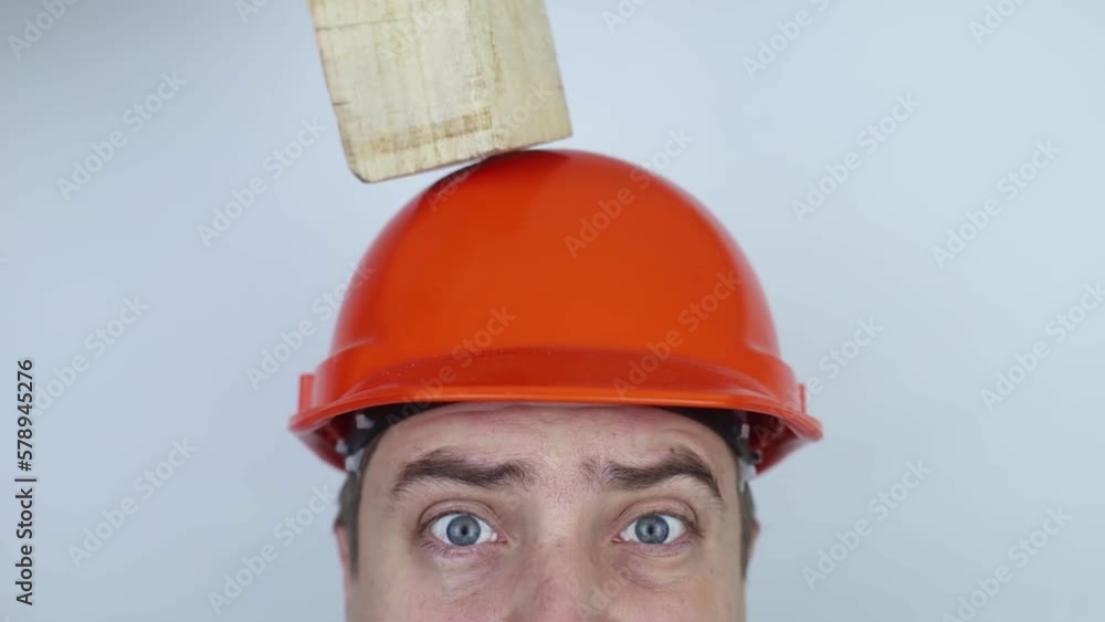Safety helmet. Brick and a board fall on builder head. Saving a life due to wearing a protective construction helmet. Protection of worker from accidents. Falling objects from a height. Slow mo effect Safety helmet. Brick and a board fall on builder head. Saving a life due to wearing a protective construction helmet. Protection of worker from accidents. Falling objects from a height. Slow mo effect