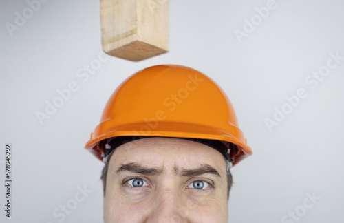 Safety helmet. Brick and a board fall on builder head. Saving a life due to wearing a protective construction helmet. Protection of worker from accidents. Falling objects from a height. Slow mo effect