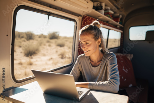 Fotografiet Digital Nomad Woman Using Laptop Inside Her Camper Van, Happy Developing Her Passion on a Sunny Day