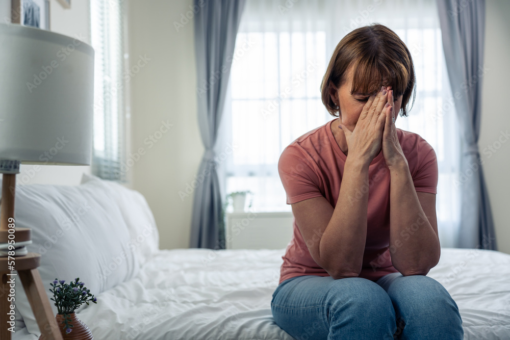 Caucasian senior older depressed woman sit alone in bedroom at home. Caucasian senior older depressed woman sit alone in bedroom at home.