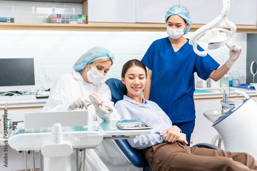 Obraz premium Caucasian dentist examine tooth for young girl at dental health clinic. 