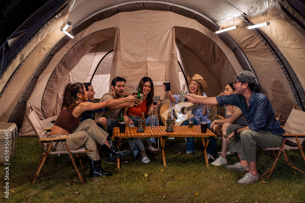 Group of diverse friend having outdoors camping party together in tent.  - obrazy, fototapety, plakaty 