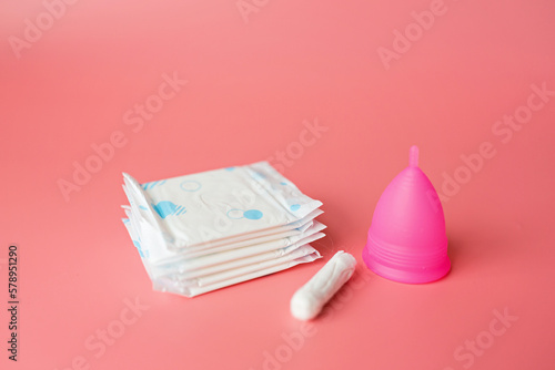 Menstrual cup, sanitary pad, tampon on pink background. Alternative feminine hygiene product during the period. Women health concept. Copy space. Eco friendly concept, zero waste product. Flat lay