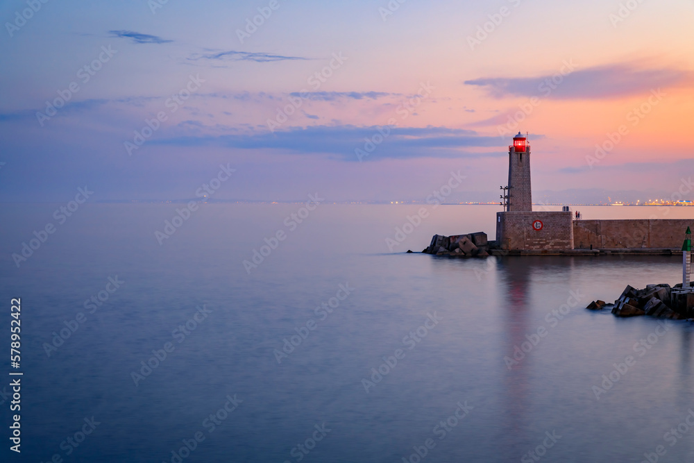 Mediterranean Sea with the lighthouse at sunset in the harbor, Nice, France