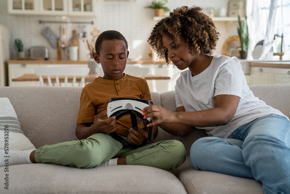 African American Mother Showing Son Vr Headset To Son While Resting African american mother showing son vr headset to son while resting