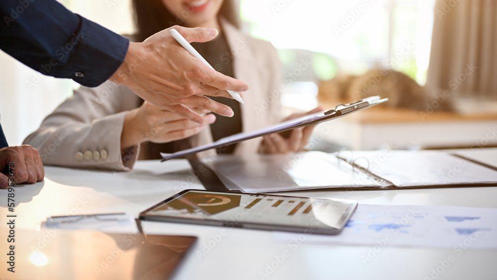 Businesspeople are in the financial meeting, analyzing financial data on report. cropped image Businesspeople are in the financial meeting, analyzing financial data on report. cropped image