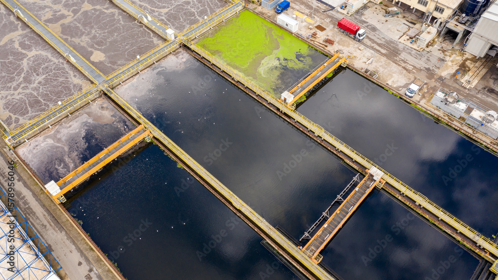 Aerial view of rectangular tanks of a sewage and water treatment plant enabling the discharge and re-use of waste water. It's a sustainable water recycling with treatment plant. Pollution concept. Aerial view of rectangular tanks of a sewage and water treatment plant enabling the discharge and re-use of waste water. It's a sustainable water recycling with treatment plant. Pollution concept.