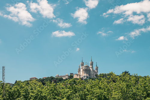Low angle view of Basilica Notre Dame de Fourviere against blue sky in city during sunny day photo
