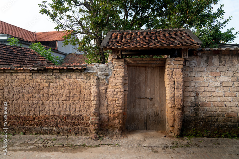 Old aged house entrance and wall made of laterite in Duong Lam ancient village, Son Tay district, Hanoi, Vietnam Old aged house entrance and wall made of laterite in Duong Lam ancient village, Son Tay district, Hanoi, Vietnam