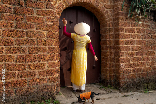 Fotografi A charming Vietnamese woman in traditional ao dai dress in the ancient village of Duong Lam, Son Tay district, Hanoi