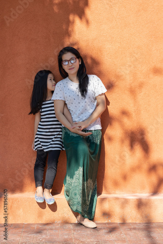 Mother and daughter by orange wall photo