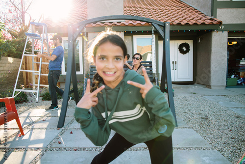 Girl photo bombs camera with mother in background in focus photo