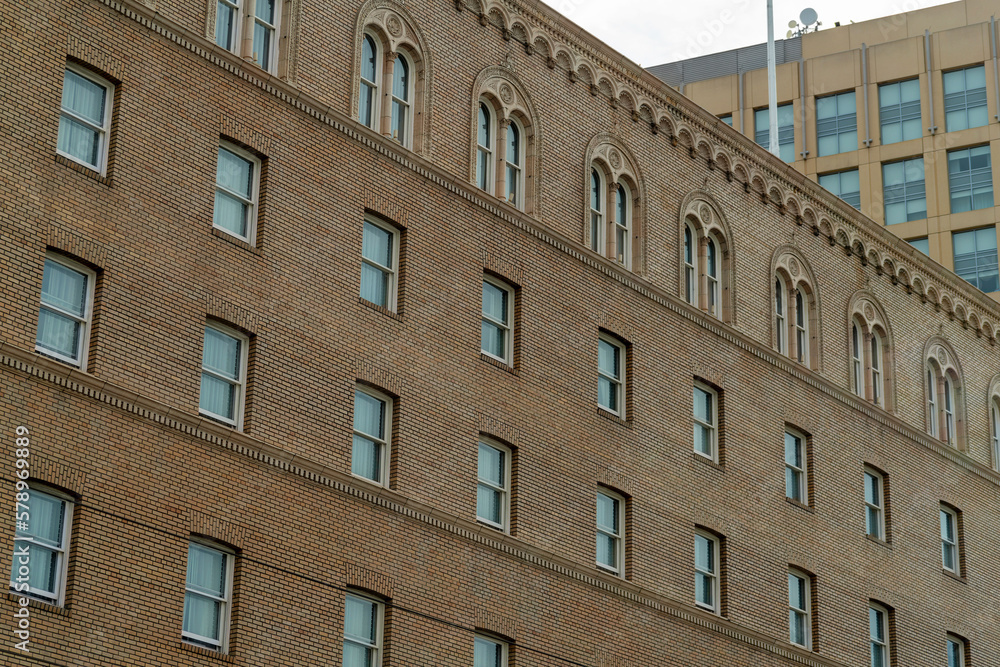 Naklejka premium Modern apartment complex building for residential or comercial real estate with many visible rows of windows and ladder