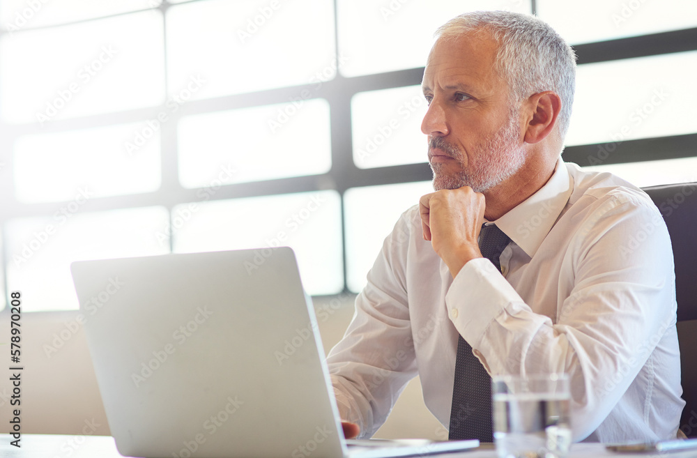 Thinking of ways to make his online visibility shine brightly. a mature businessman using a laptop in an office. Thinking of ways to make his online visibility shine brightly. a mature businessman using a laptop in an office.