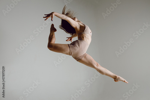Fotografiet Young woman dancer dancing high heels dance jumping leg-split