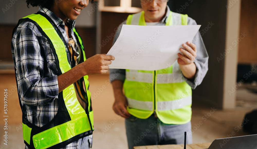 Architect caucasian man and woman working with colleagues mixed race in the construction site. Architecture engineering on big project. Building in construction process interior. Architect caucasian man and woman working with colleagues mixed race in the construction site. Architecture engineering on big project. Building in construction process interior.